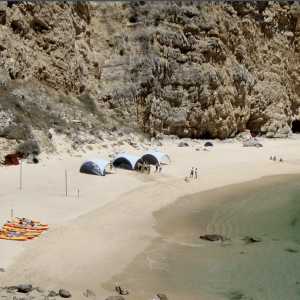 Event day on a secluded beach in Lisbon with water activities, fun, salad buffet