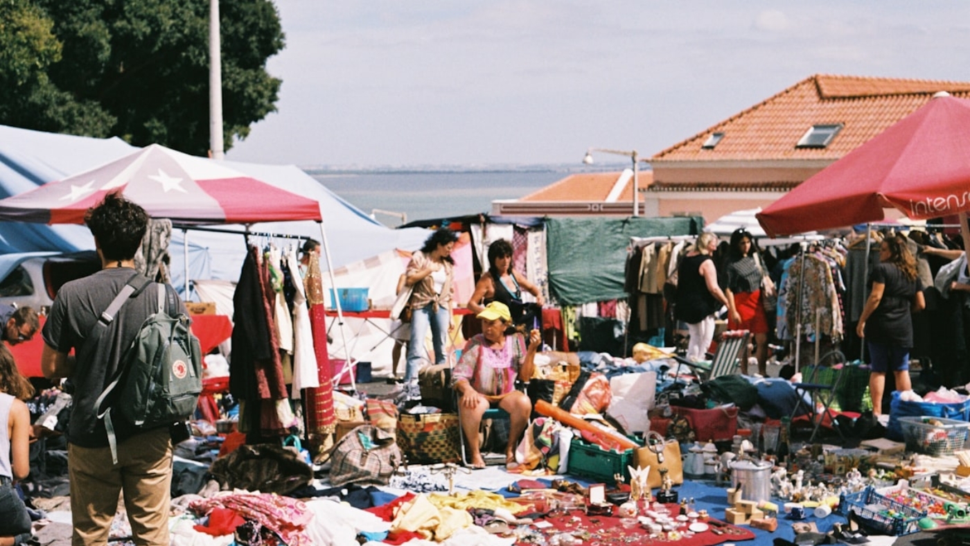 Feira da Ladra flea market in Lisbon with colourful stalls and river view