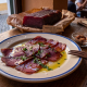 Muxama, atún curado portugués, servido con aceite de oliva y vino en POP en Graça, Lisboa